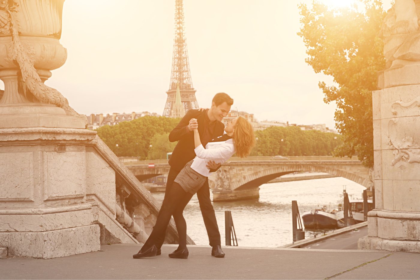 A couple dancing on a Paris bridge at golden hour, the Eiffel Tower behind them